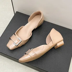 Vue détaillée de ballerines élégantes en cuir verni beige avec boucle carrée décorative.