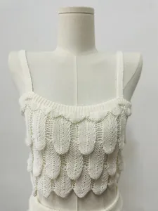 Detail van witte gehaakte top met een gelaagde textuur met veren-effect patroon