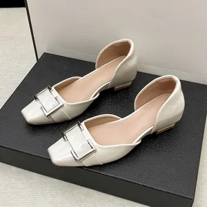Détail des chaussures plates d'Orsay françaises crème avec une boucle carrée élégante.