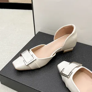 Gros plan sur d'élégantes ballerines Mary Jane blanc cassé avec boucle carrée iconique