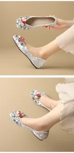 Detail of grey velvet flat shoes featuring colorful rhinestones and floral embellishments.