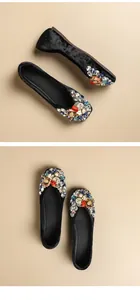Macro view of black velvet flat shoes featuring vibrant rhinestone and bead embellishments