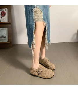 Détail de haute qualité des sabots beiges cloutés avec boucle ajustable