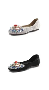 Detailed view of women's velvet ballet flats with colorful jewel embellishments