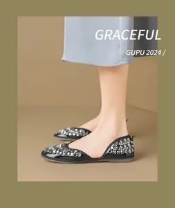 Primo piano di ballerine nere con decorazioni in strass scintillanti e ritagli laterali.