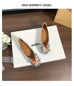 Nahaufnahme eleganter silberner Ballerinas mit farbigem Strass und Kristallschmuck.