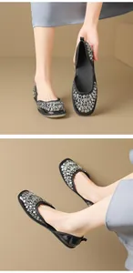 Dettaglio di eleganti ballerine nere con strass e un raffinato design traforato