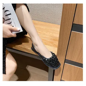 Dettaglio di eleganti scarpe basse nere con decorazioni in strass e design a rete