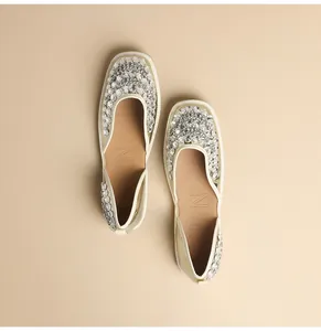 Dettaglio di eleganti scarpe basse in stile francese con decorazioni di strass.