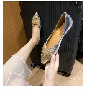 Detailansicht silberner spitzer Ballerinas mit funkelndem goldenem Strassbesatz