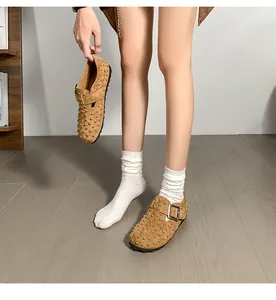 Vue détaillée de mules marron cloutées avec boucle métallique et chaussettes blanches