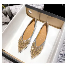 Nahaufnahme von silbernen spitzen Ballerinas mit goldenen Pailletten im Karton