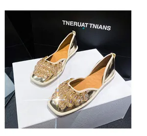 Dettaglio di sandali bassi in stile francese con decorazioni in strass scintillanti