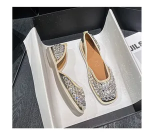 Nahaufnahme eleganter französischer flacher Sandalen mit glitzernden Strasssteinen.