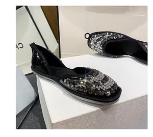 Detailansicht schwarzer Lackleder-Flats mit üppigem Strassbesatz und freier Seite