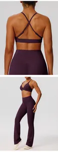 Detail of deep purple yoga set showing cross-back sports bra and flared yoga pants.