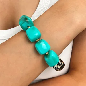 Makro-Detailansicht des böhmischen Armbands mit türkisen und Leoparden-Perlen am Handgelenk
