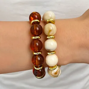Nahaufnahme von handgefertigten böhmischen Perlenarmbändern in Bernstein und Marmorweiß