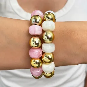 Nahaufnahme eines böhmischen handgefertigten Perlenarmbands mit rosa weißen goldenen Perlen.