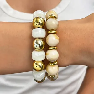 Detailaufnahme von handgefertigten böhmischen Perlenarmbändern in Marmor und Gold.