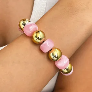 Detailaufnahme eines böhmischen Armbands mit goldfarbenen und rosa marmorierten Perlen.