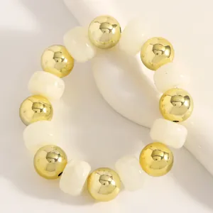 Detailansicht eines böhmischen Armbandes mit abwechselnden Gold- und Cremekugeln.