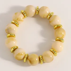 Detailansicht der cremefarbenen Marmorperlen und goldenen Abstandsringe dieses Armbands