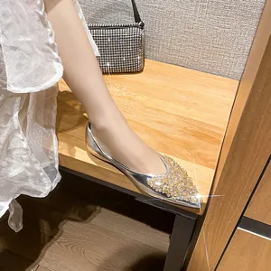 Eleganti ballerine a punta argento con strass dorati indossate da una modella su panca