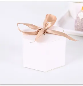 Elegant hexagonal white paper gift box detail featuring a champagne silk ribbon bow