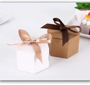 Hexagonal white and kraft gift boxes with elegant ribbon bows for candy or treats.