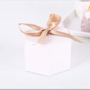 Elegant white hexagonal gift box with a champagne silk ribbon bow detail for favors