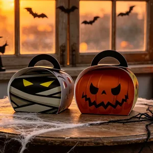 Halloween pumpkin and mummy candy boxes displayed on a rustic table with cobwebs.