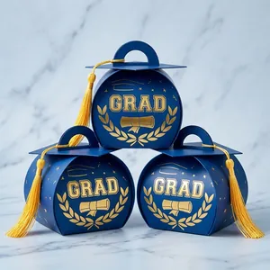 Close-up of elegant 3D graduation cap candy boxes with golden tassels and GRAD print