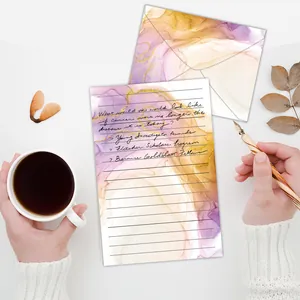 Detail view of watercolor letter paper and matching envelope with purple ink design