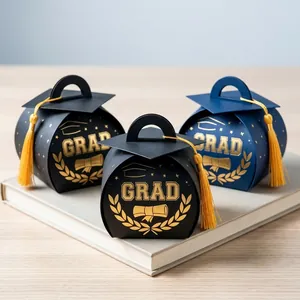 Close-up detail of three gold foil graduation cap candy boxes with elegant yellow tassels