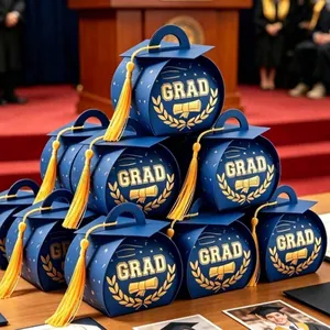 Pile of blue graduation cap gift boxes with gold foil GRAD text and tassels