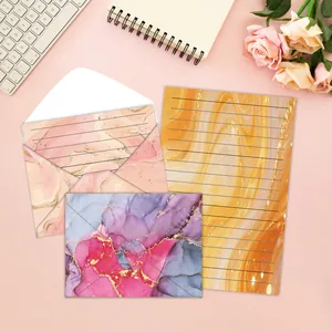 Detail view of watercolor stationery set featuring marble pattern envelopes and lined paper.