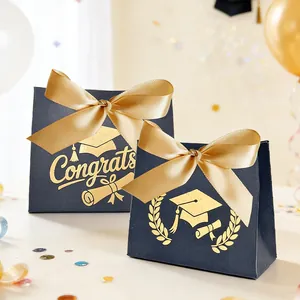 Detailopname van afstudeercadeauzakjes met gouden folie en satijnen strikken