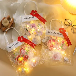 Dettaglio di biglietti d'auguri floreali fai-da-te con luci LED e confezione elegante