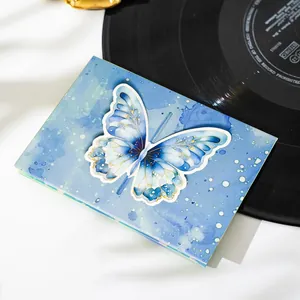 Primo piano di un biglietto pop-up a farfalla 3D blu con un design artistico ad acquerello