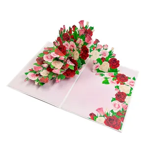 Close-up of 3D pop-up greeting card featuring a lush red and pink rose bouquet.