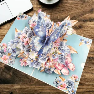 Prachtige 3D pop-up wenskaart met ingewikkelde blauwe vlinder en bloemmotieven.