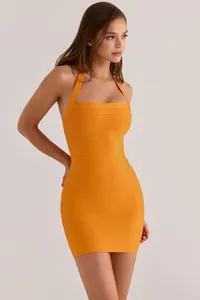 Close-up detail of an orange bandage halter-neck mini dress with horizontal texture