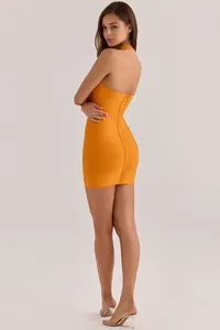 Detail view of a sexy orange bodycon bandage dress featuring a halter neck and back zipper.