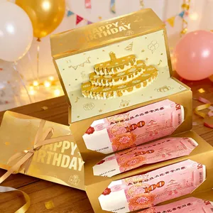 Primer plano de tarjeta de cumpleaños 3D dorada con pastel y ranuras para dinero.