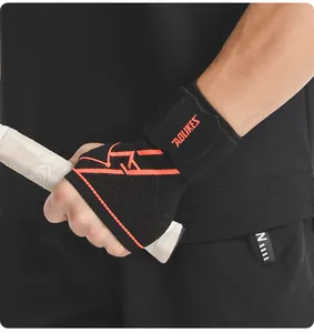 Detail of a black fly-knit compression wrist brace with orange accents on a hand