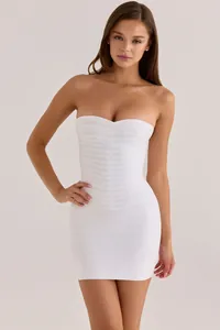 Detailed view of white strapless bodycon bandage mini dress with elegant V-patterning.