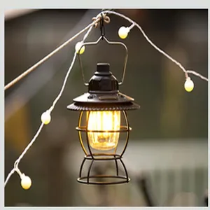 Retro vintage outdoor camping lantern hanging on decorative string lights in a garden scene