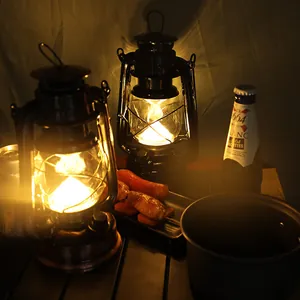 Primo piano di lanterne da campeggio a LED retrò in un accogliente ambiente esterno notturno.