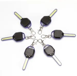 Gros plan de six mini lampes de poche LED porte-clés avec bandes COB sur fond blanc